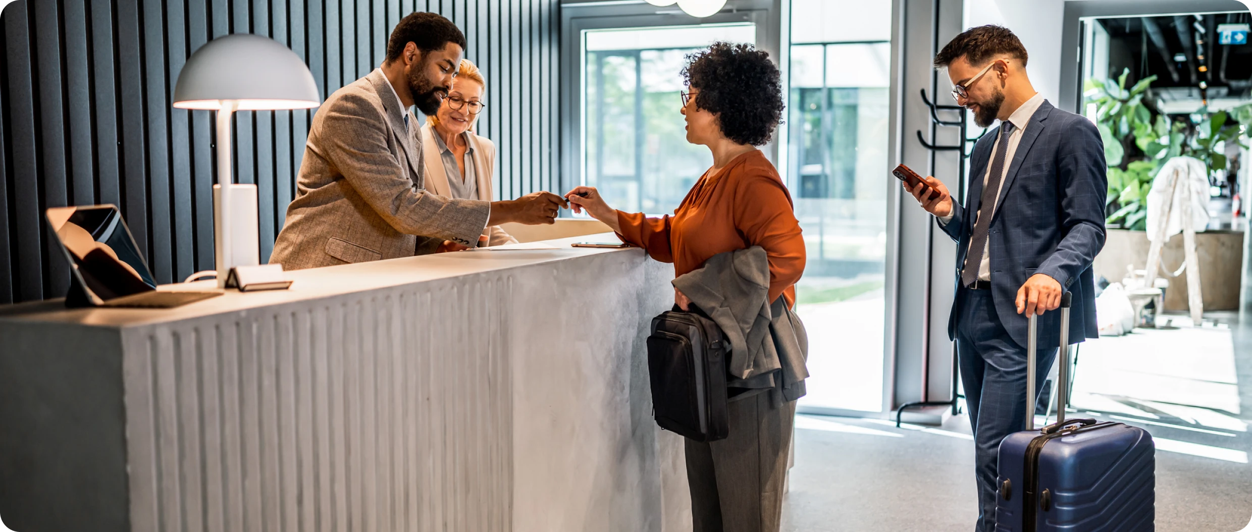 Hotel check-in with guests and receptionist.