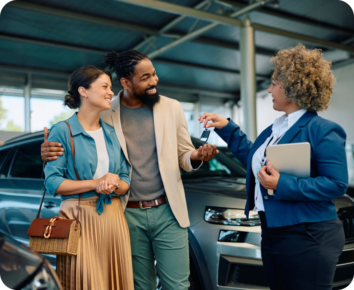 Couple receiving car keys from salesperson.